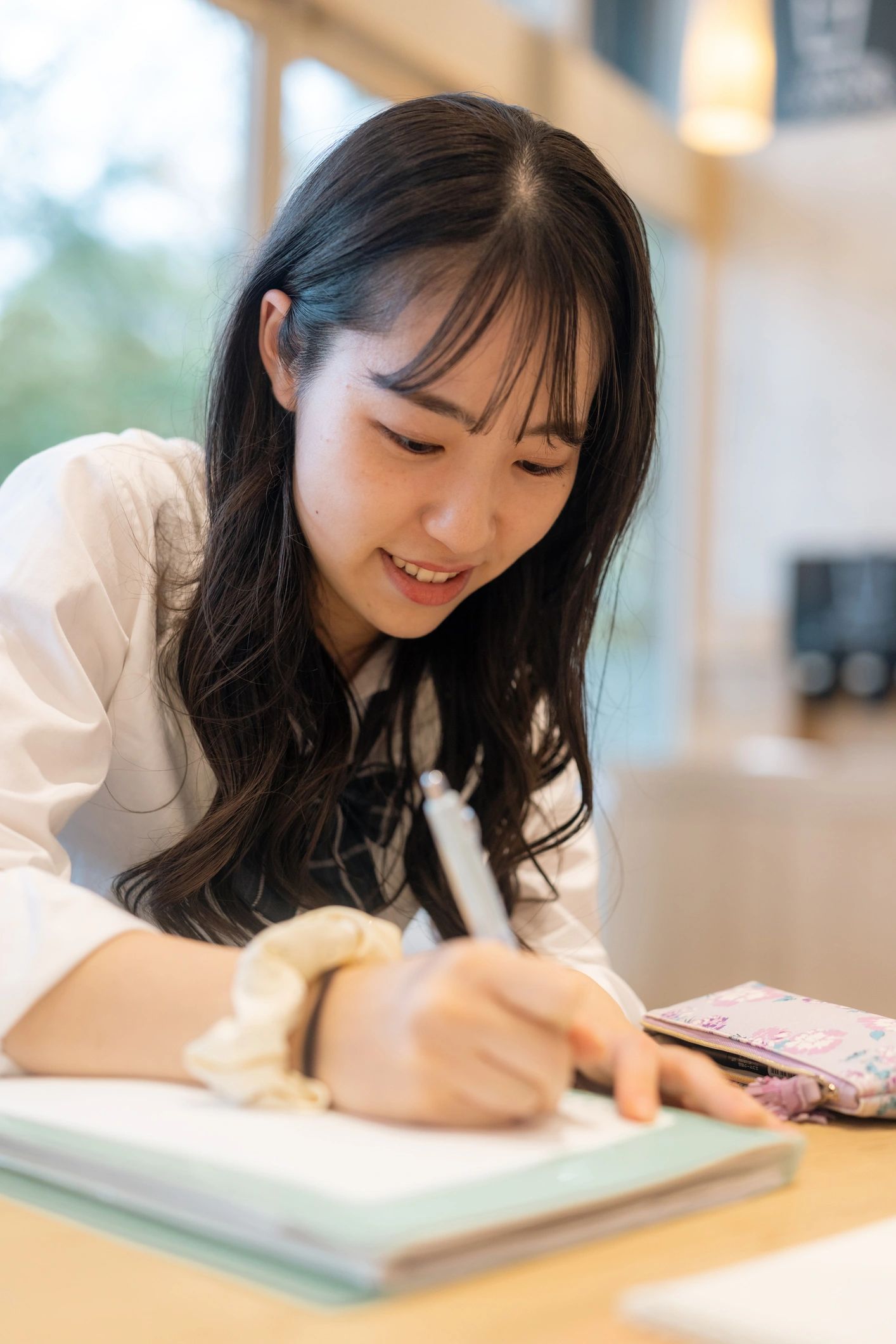 Young woman writing with a smile.