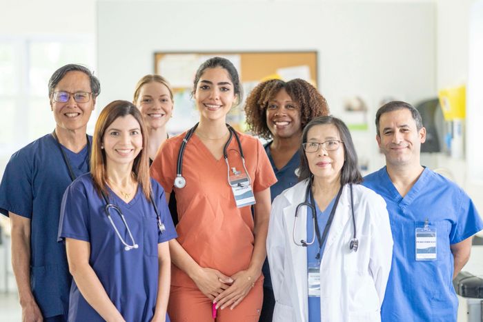 A diverse group of smiling healthcare professionals posing together.
