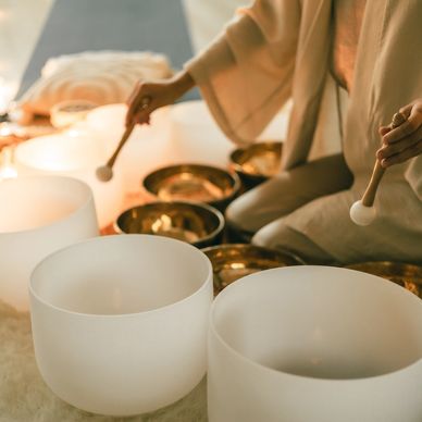 Person playing crystal singing bowls and metal singing bowls for sound therapy.