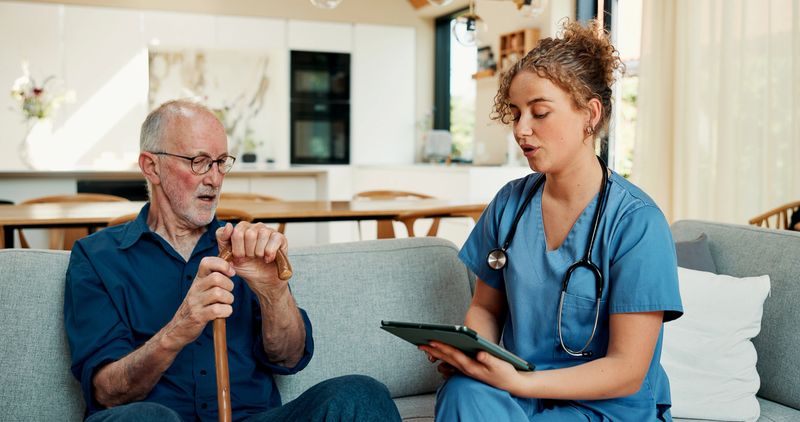 Home, tablet and nurse with senior man for medical checkup, consulting and online results. Retirement, assisted living and caregiver with mature patient on tech for health exam, support and talking