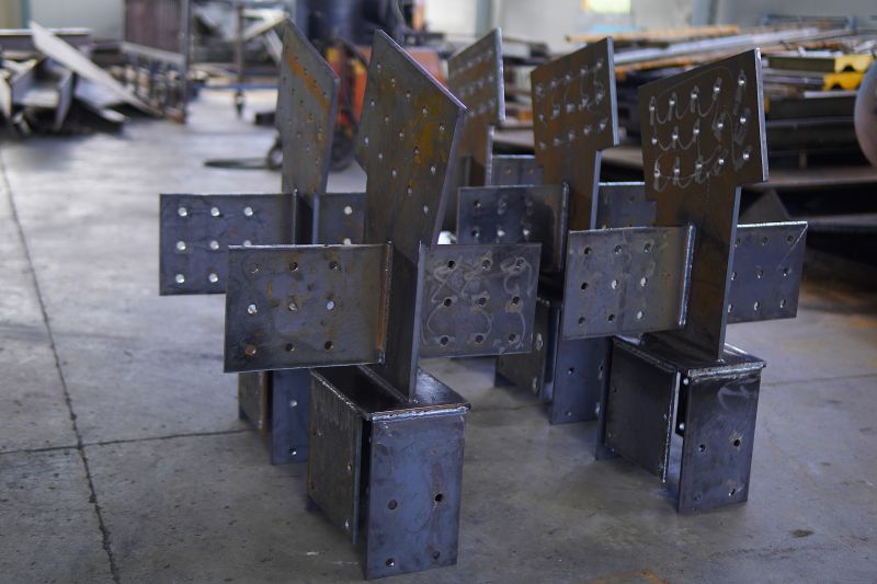 Steel structures, metalwork, and welding. Large steel components in an industrial workshop. Structural steel with welded joints and bolt holes.