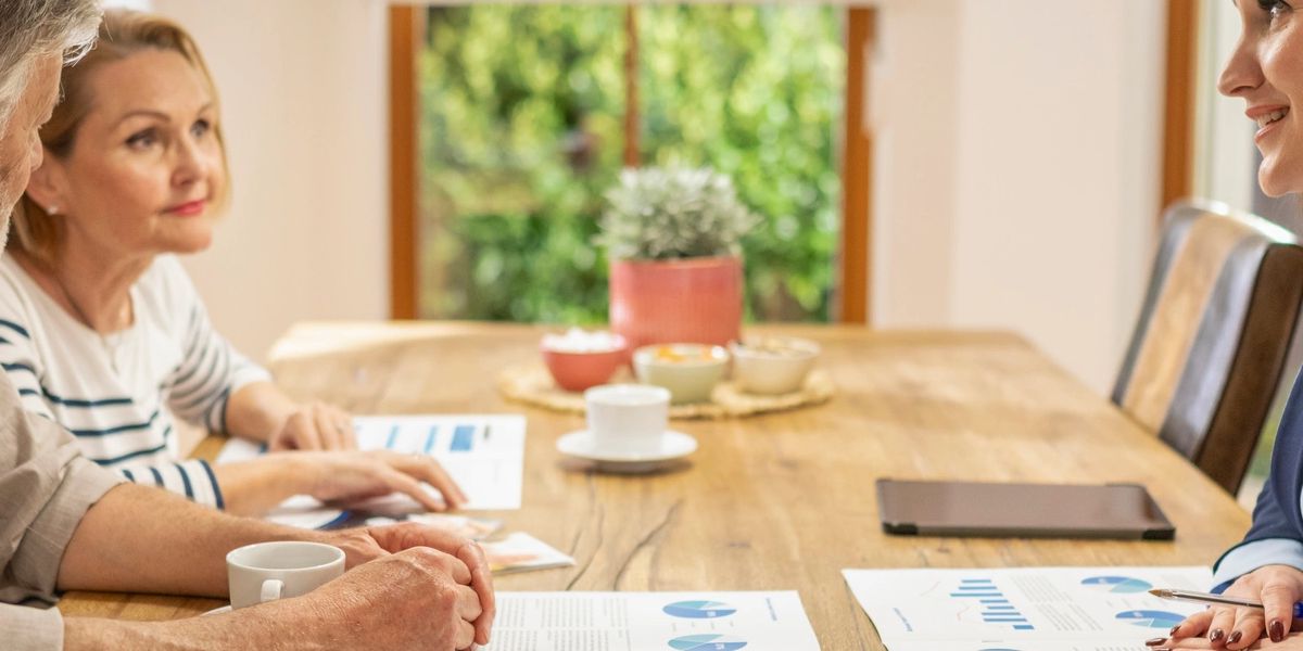 Homeowner couple reviewing mortgage documents at kitchen table