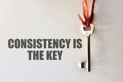 A key hanging with text 'Consistency is the key'.