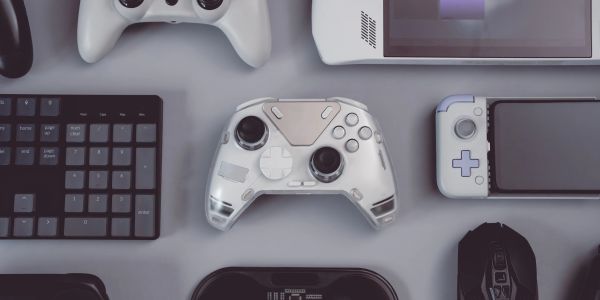 Various gaming controllers and devices on a gray surface.