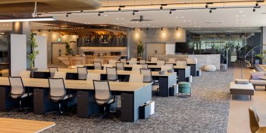 Modern open office space with multiple desks and chairs.