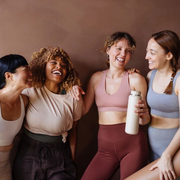 Four women smiling and bonding together.