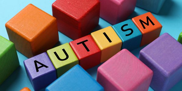 Colorful blocks spelling out AUTISM on a blue background.