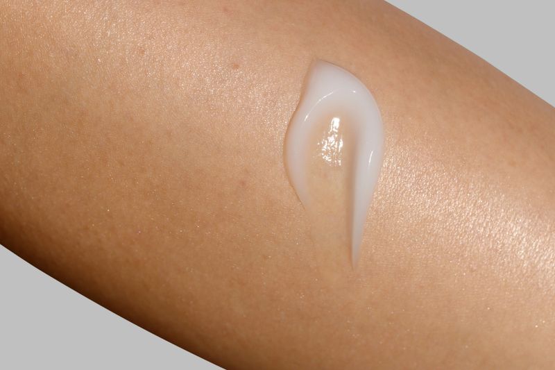 Close-up macro shot of a skincare cream applied on a womans skin. Cosmetic skincare product texture. Face cream, body lotion swipe swatch