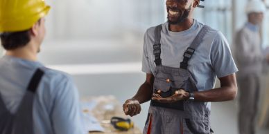 Two construction workers smiling and talking.