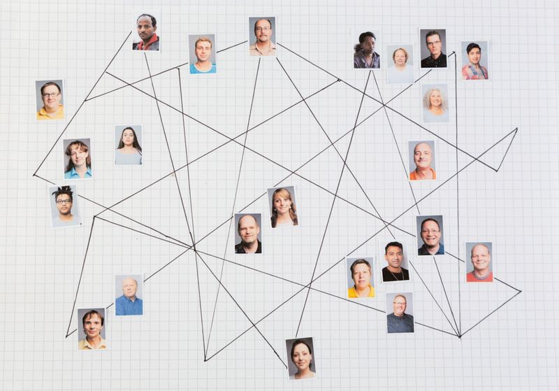 Mixed media collage: photo prints of portraits on graph paper,connected with black  lines drawn on the paper, concept of connection, communication, network, the portraits show a variety of people, concerning gender, age and race