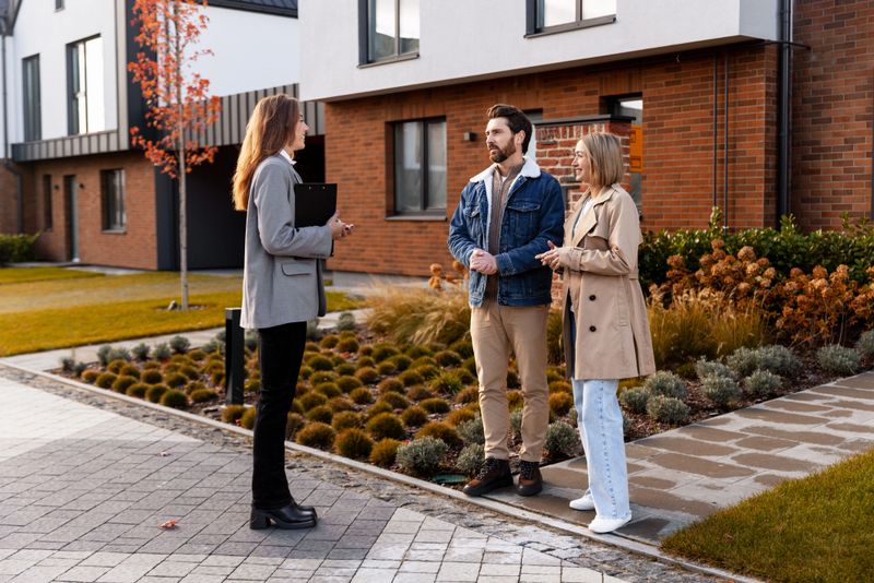 Real estate agent talking with a couple while viewing a modern house for sale