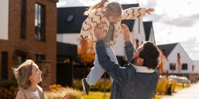 Happy family playing outside their home.