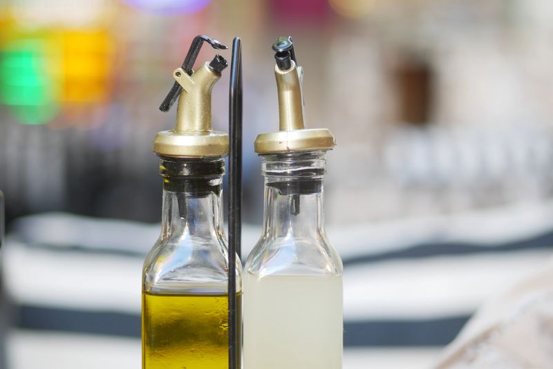 Glass containers hold olive oil and vinegar, ready for diners to use.