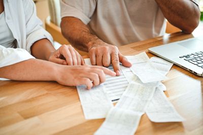 Two people examining receipts and bills together.