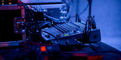 Audio mixing console setup with cables and equipment.