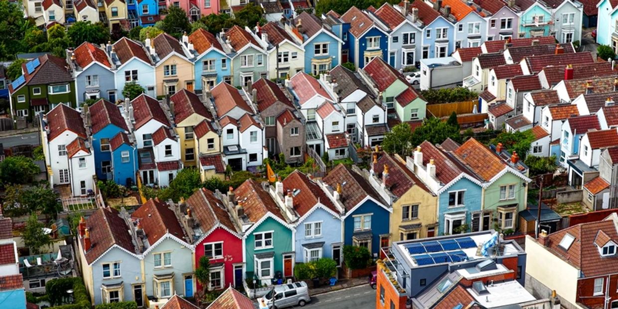 Aerial view of colorful, densely packed houses with tiled roofs in a residential neighborhood.