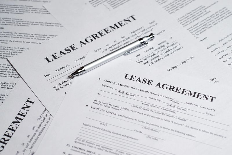 Paper lease agreement forms with pen. Concept of renting a home. Top view. Document is mock-up