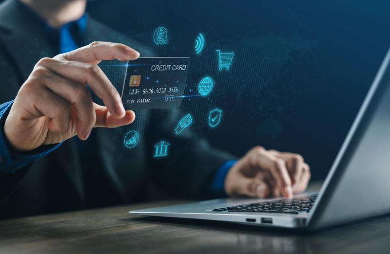 A businessman using a credit card for online payment on a laptop, symbolizing digital banking, fintech innovation, secure transaction, and modern e-commerce technology for global financial business.