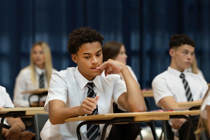 Nervous high school student sitting an exam in a large hall