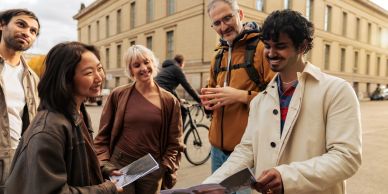Group of diverse people sharing travel maps outside.