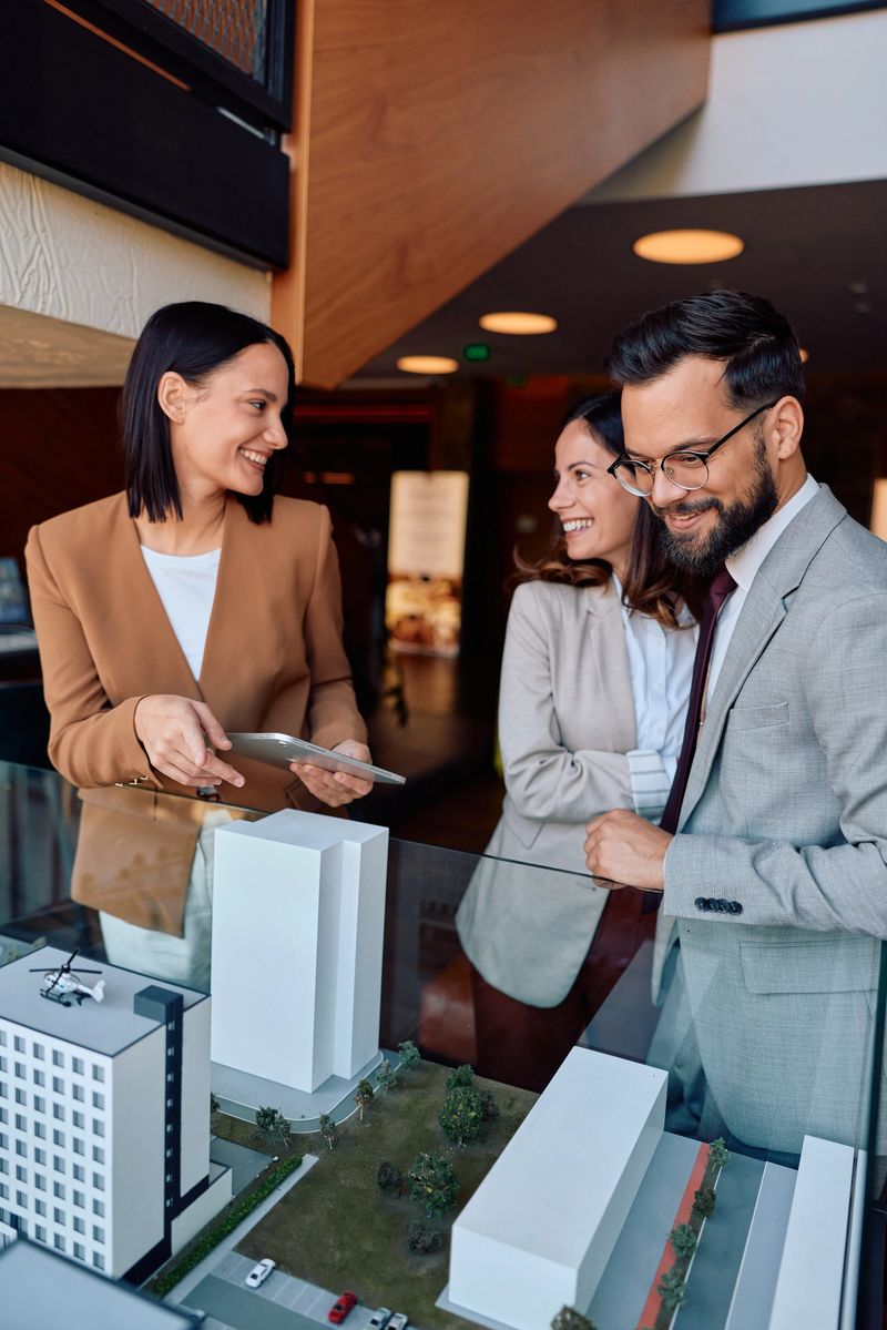 Business professionals discussing a new construction project and urban development, using a detailed architectural model to visualize investment opportunities and future plans in a modern office