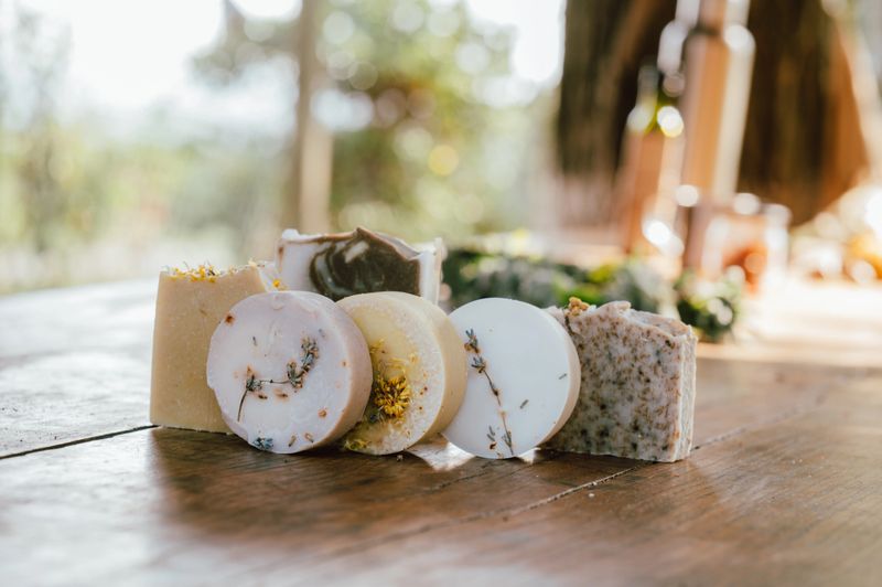 smallscale soap maker arranging handcrafted products on vintage wooden table for promotion
