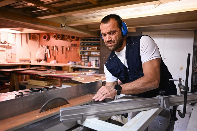 Carpenter cutting wood with a precision circular saw