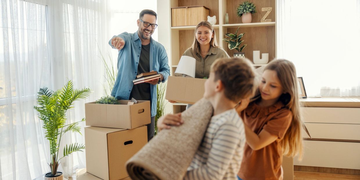 Family happily unpacking boxes in a bright new home.