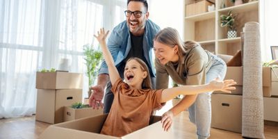 Happy family playing in cardboard boxes during a move.