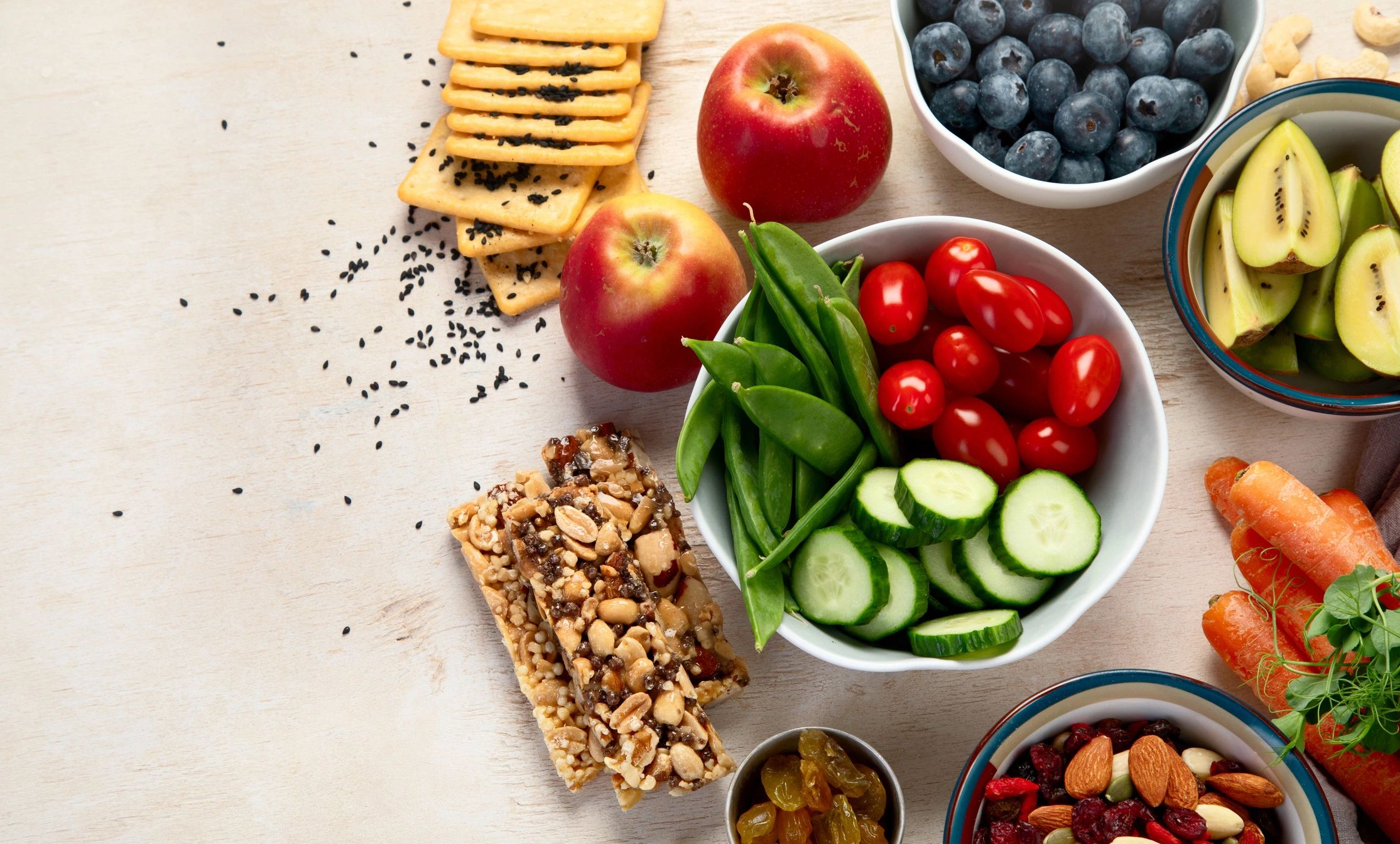 Healthy snacks including fruits, vegetables, nuts, and granola bars.