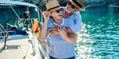 Happy couple embracing on a boat by sparkling water.
