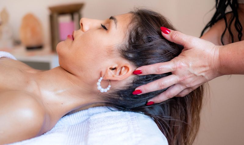 Woman enjoying a relaxing head massage at a spa or wellness center