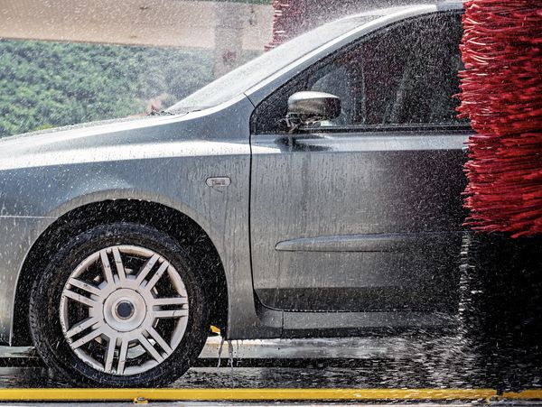 Silver car entering automated wash.
