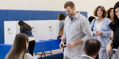 People participating in a voting process at a polling station.