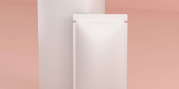 Minimalist white pouch packaging against a soft pink and white background.