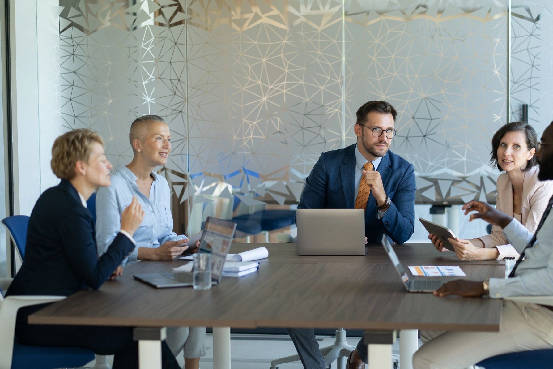A diverse group discussing in a modern office meeting.