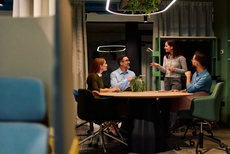 Business team engaged in a productive meeting, discussing ideas and sharing insights in a contemporary office setting, fostering teamwork and professional development