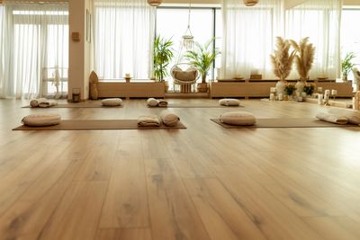 Calm yoga studio with mats, cushions, and natural light.