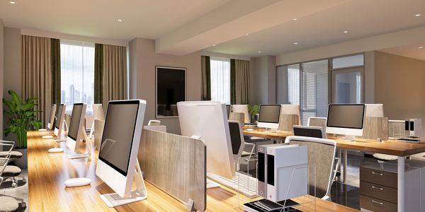 Modern office workspace with sleek computers and wooden desks.