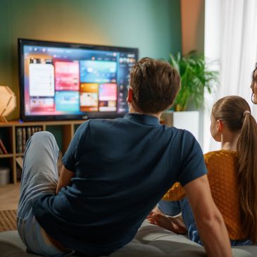 Family watching TV together in a cozy room.