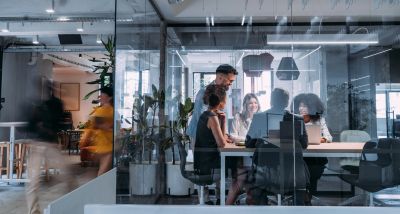 Team collaborating in a modern glass-walled office meeting room.