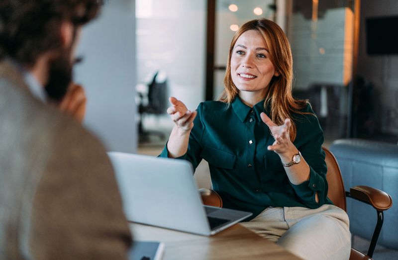 Shot of two colleagues having a discussion in the office. Creative business persons discussing new project and sharing ideas in the workplace.