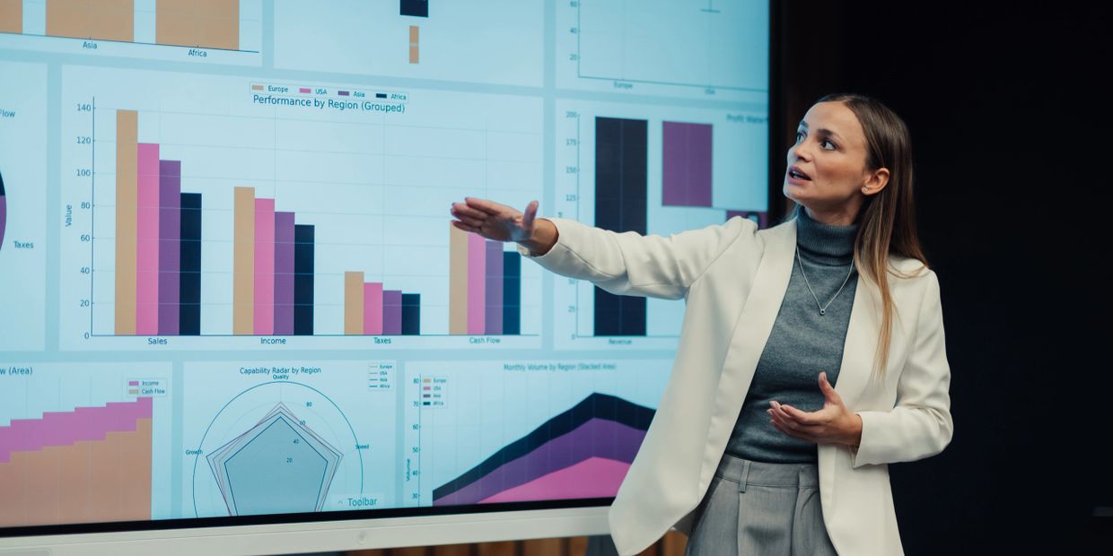 A woman presenting business charts and graphs during a professional presentation.