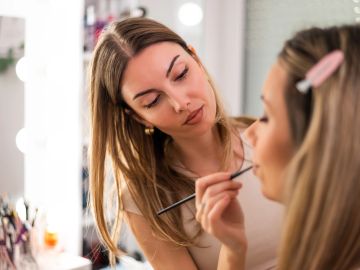 Makeup artist applying makeup on a woman.