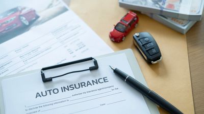 Auto insurance form with car key and toy car.