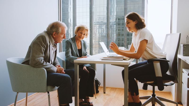 Senior Couple Meeting With Female Financial Advisor In Office