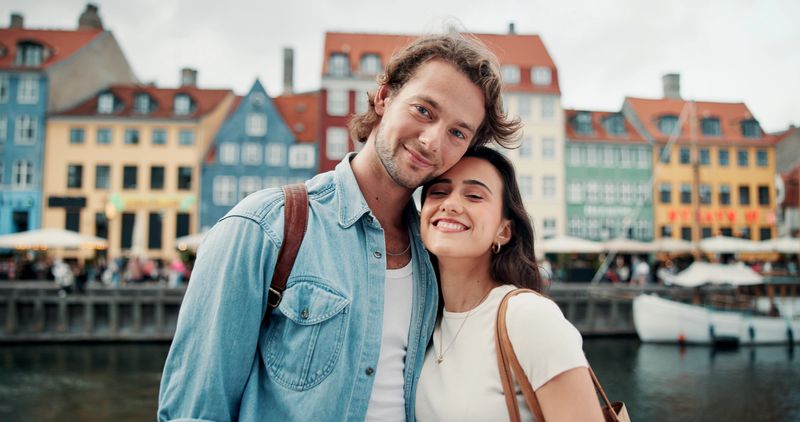 Couple, hug and portrait in city, love and commitment for relationship, outdoor and romance on break. Happy, man and embrace with woman on weekend, bonding and people on date or smile in Denmark