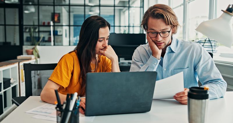 Business professionals reviewing monthly financial reports and documents at a desk