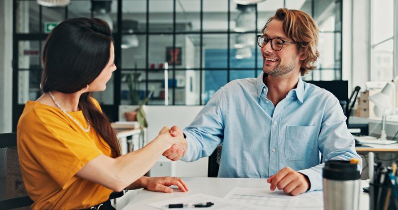 Meeting, handshake and business people in office for discussion, deal or offer on project. Collaboration, partnership and shaking hands for public relations with client for multimedia contract