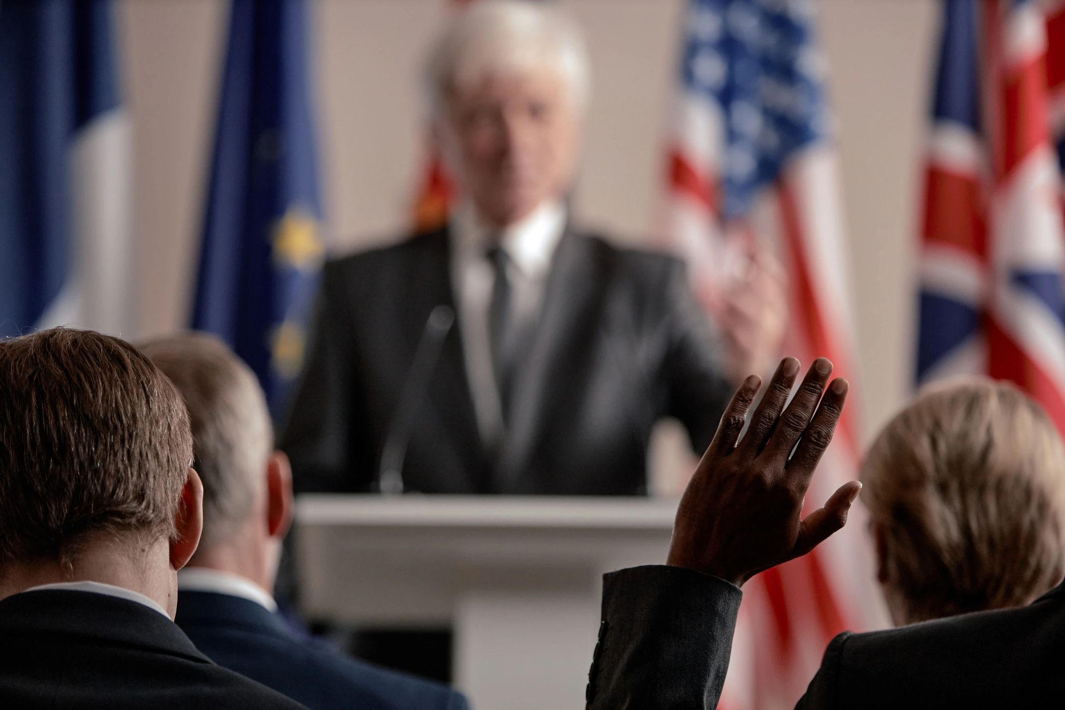 Audience member raising hand during a speech.